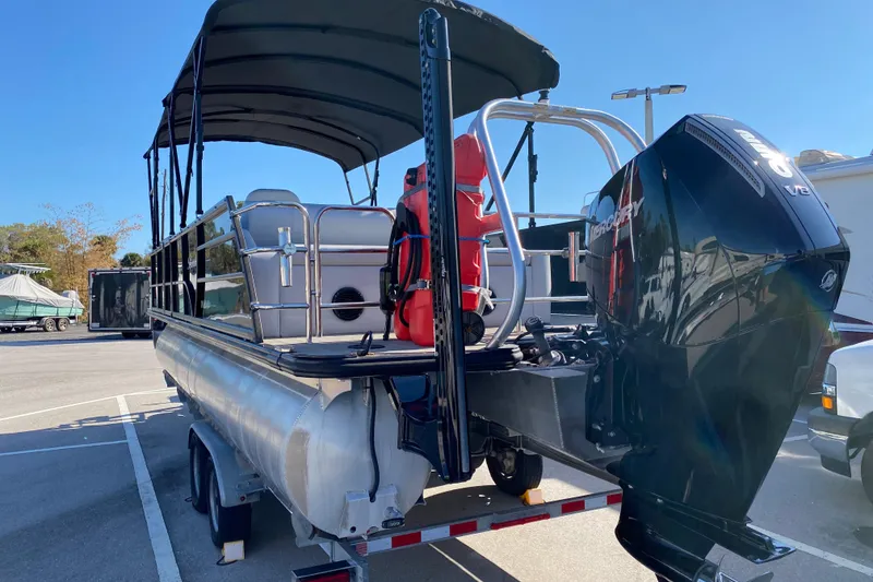 Slide: The Image of 2024 Bentley Pontoons Legacy Swingback with Mercury V12 engine, parked on a trailer. - 4