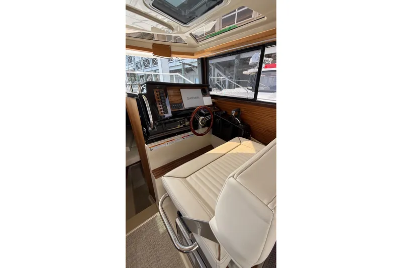 Slide: The Image of 2026 Ranger Tugs R-27 helm with Garmin navigation, luxurious seating, and modern controls. - 12