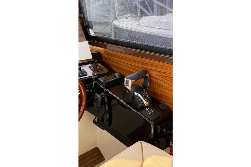 Slide: The Image of 2026 Ranger Tugs R-27 helm station with modern controls and wood paneling. - 14