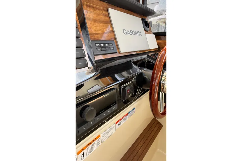 Slide: The Image of 2026 Ranger Tugs R-27 helm with Garmin navigation and wood accents. - 16