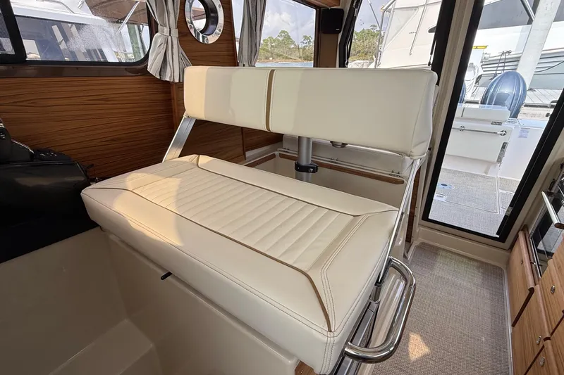 Slide: The Image of Interior of 2026 Ranger Tugs R-27, featuring a stylish cream-colored seat and wooden accents. - 18