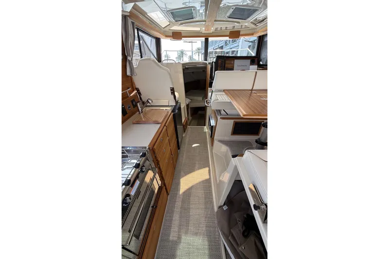 Slide: The Image of Interior of 2026 Ranger Tugs R-27, featuring modern kitchen and seating area. - 20