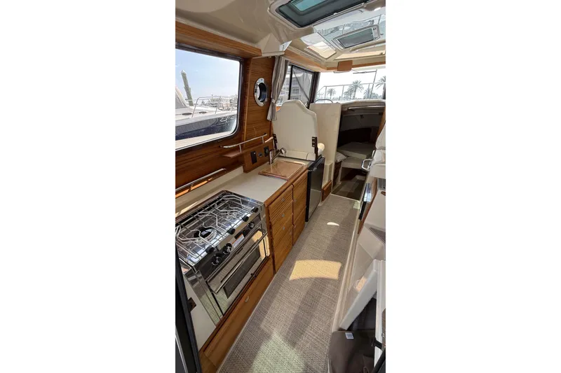 Slide: The Image of 2026 Ranger Tugs R-27 interior with modern kitchen and cozy cabin space. - 22