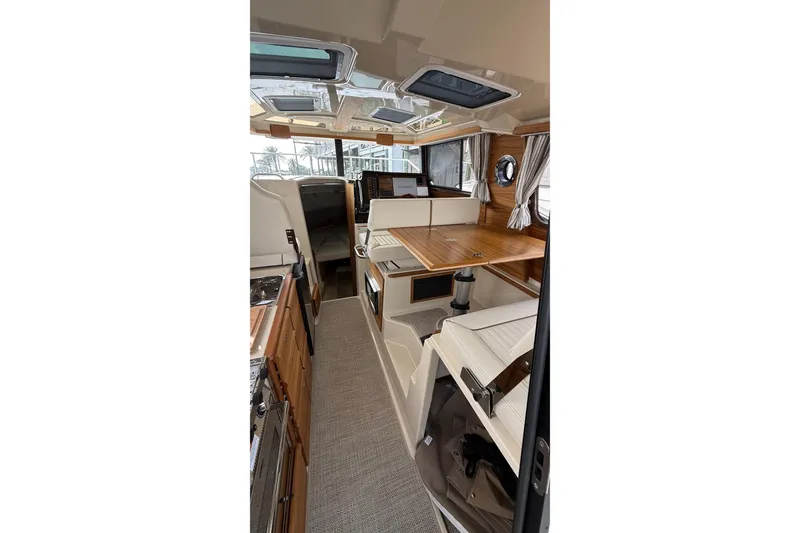 Slide: The Image of Interior of 2026 Ranger Tugs R-27 boat, featuring a cozy cabin with wood accents. - 27