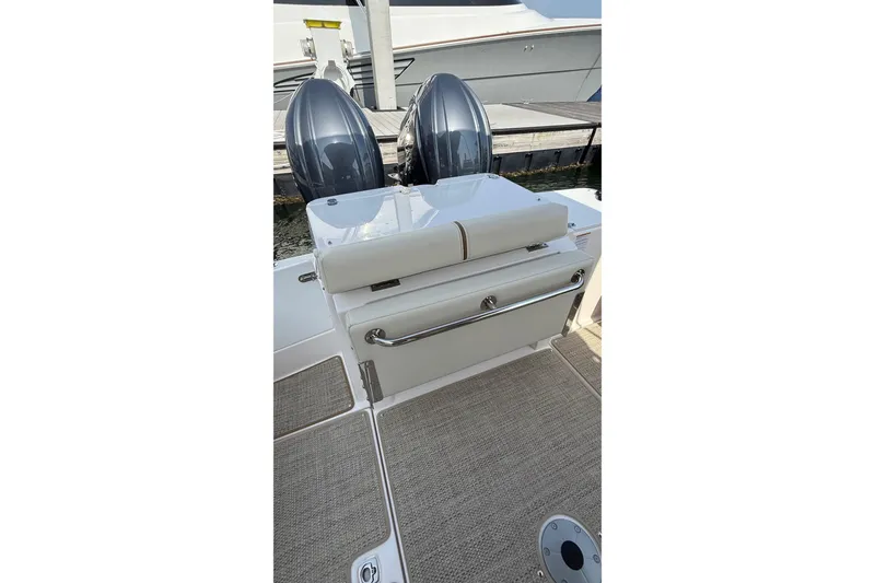 Slide: The Image of 2026 Ranger Tugs R-27 boat with dual outboard motors and cushioned seating. - 6