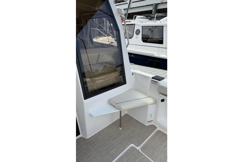 Slide: The Image of 2026 Ranger Tugs R-27 boat interior with seating and window view. - 9