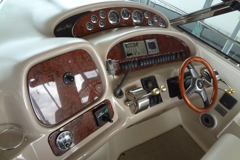 Slide: The Image of 2001 Sea Ray 380 Sundancer helm with wood accents and modern controls. - 21