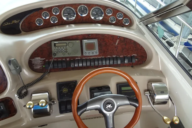 Slide: The Image of 2001 Sea Ray 380 Sundancer helm with wood accents and modern controls. - 22