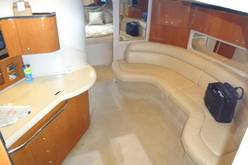 Slide: The Image of Interior of 2001 Sea Ray 380 Sundancer with beige leather seating and wooden cabinetry. - 29