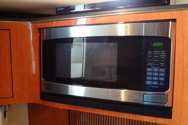 Slide: The Image of Microwave in 2001 Sea Ray 380 Sundancer yacht kitchen, featuring wood cabinetry. - 31