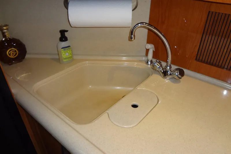 Slide: The Image of 2001 Sea Ray 380 Sundancer kitchen sink with faucet and countertop accessories. - 33