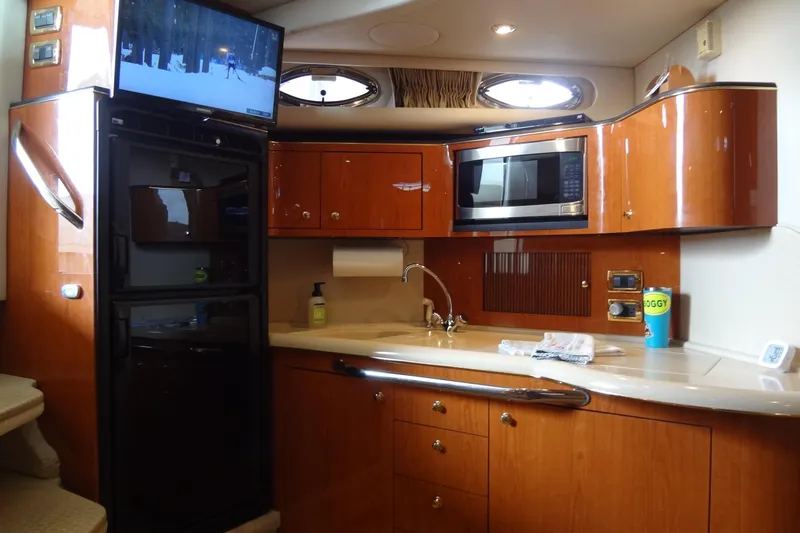 Slide: The Image of Interior of 2001 Sea Ray 380 Sundancer yacht with kitchen amenities and TV. - 34