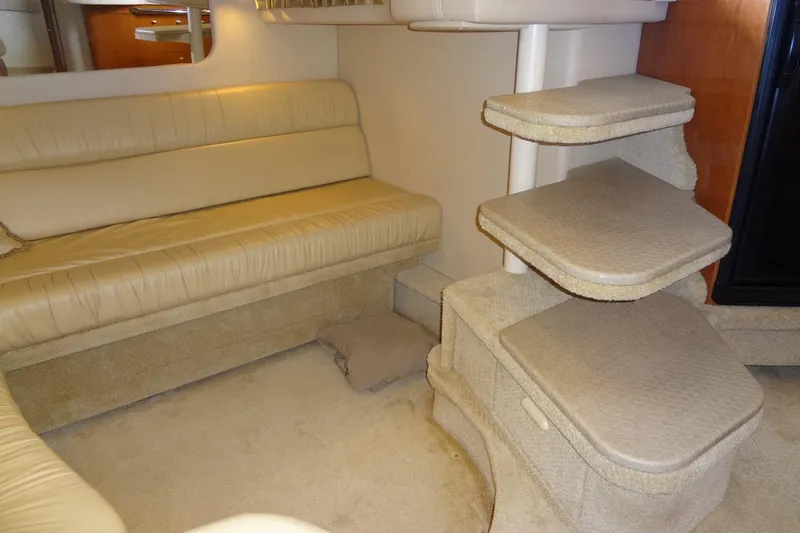 Slide: The Image of Interior of 2001 Sea Ray 380 Sundancer with beige seating and carpeted steps. - 35