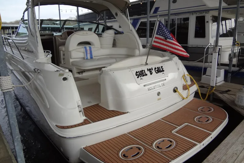 Slide: The Image of 2001 Sea Ray 380 Sundancer docked, featuring a spacious deck and American flag. - 4