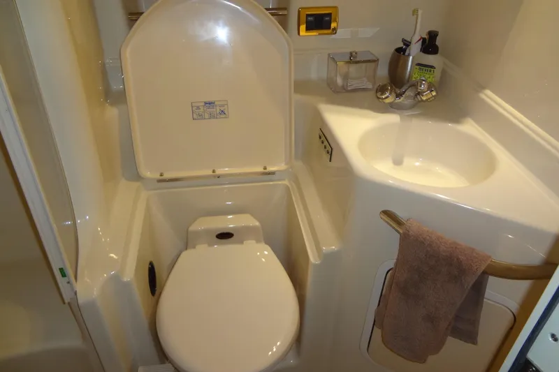 Slide: The Image of 2001 Sea Ray 380 Sundancer bathroom with toilet, sink, and towel rack. - 46