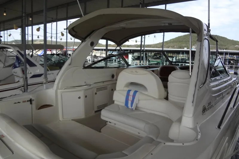 Slide: The Image of 2001 Sea Ray 380 Sundancer yacht interior at marina, showcasing seating and helm area. - 5