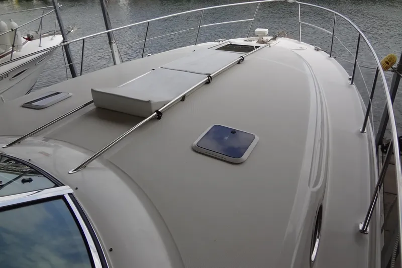 Slide: The Image of 2001 Sea Ray 380 Sundancer boat deck with railing, docked by the water. - 7