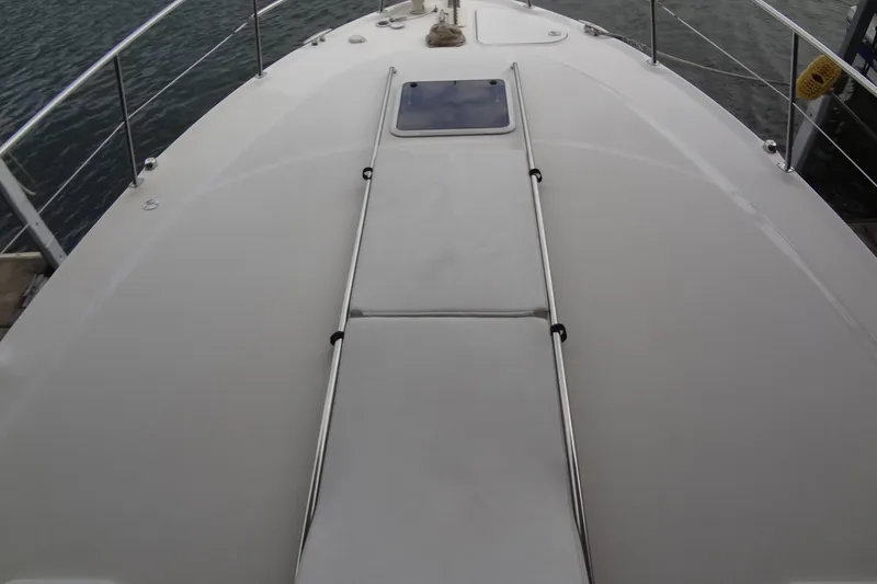 Slide: The Image of 2001 Sea Ray 380 Sundancer boat deck with railing and hatch, on calm water. - 8