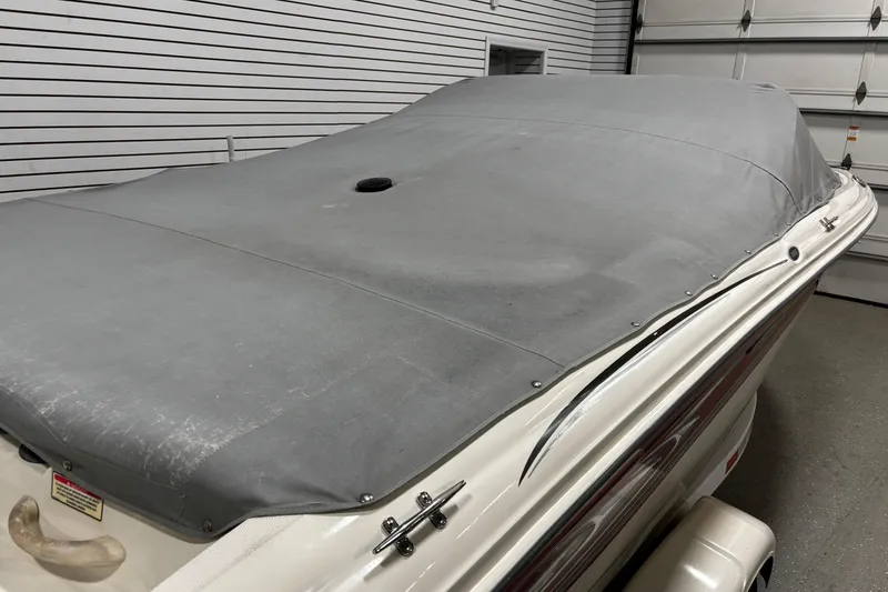 Slide: The Image of 2004 Sea Ray 185 Bow Rider boat with gray cover in garage. - 11