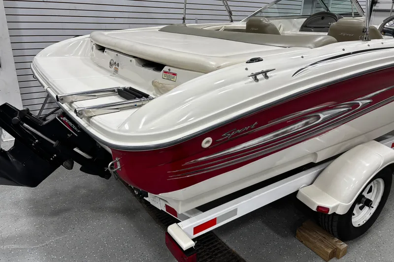 Slide: The Image of 2004 Sea Ray 185 Bow Rider boat with red and white design on trailer. - 13