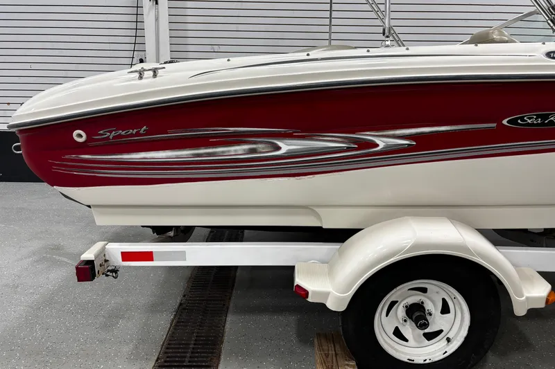 Slide: The Image of 2004 Sea Ray 185 Bow Rider boat on trailer, red and white design. - 14
