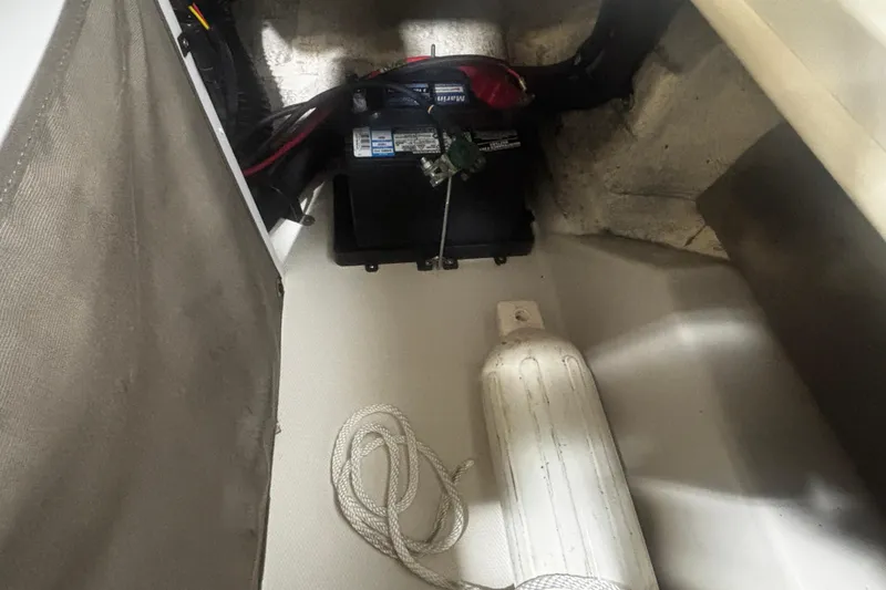 Slide: The Image of 2004 Sea Ray 185 Bow Rider interior with battery and boat fender. - 30