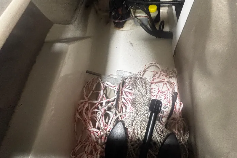 Slide: The Image of Storage compartment of a 2004 Sea Ray 185 Bow Rider with ropes and equipment. - 31