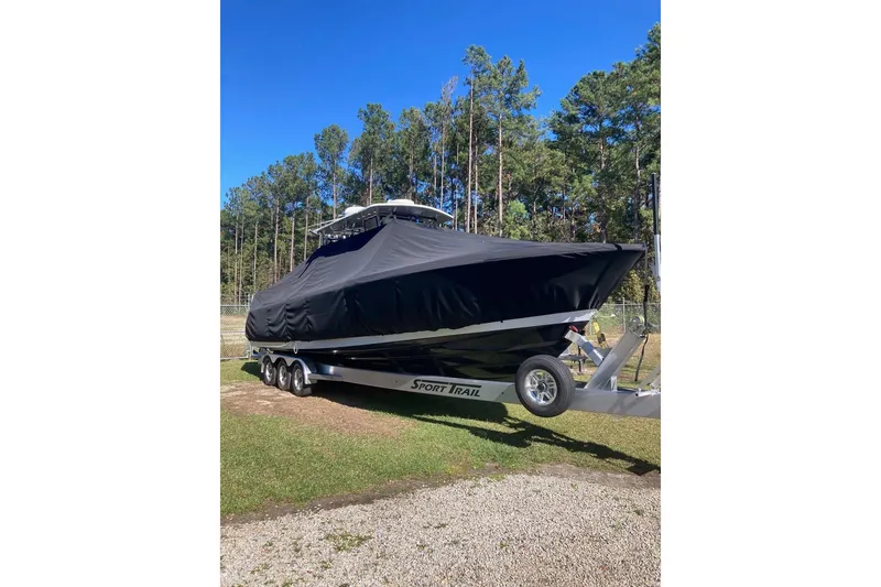Slide: The Image of Covered 2022 Sea-Lion 34 TE boat on trailer, surrounded by trees. - 42
