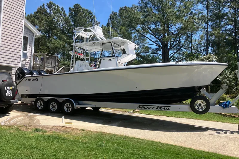 Slide: The Image of 2022 Sea-Lion 34 TE boat on trailer, parked in driveway near house. - 45