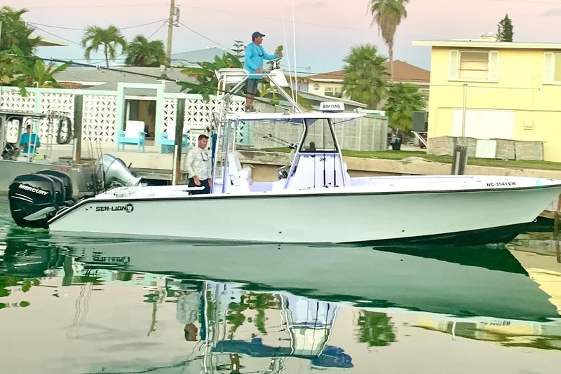 Slide: The Image of 2022 Sea-Lion 34 TE boat docked, featuring Mercury engines, with two people onboard. - 46