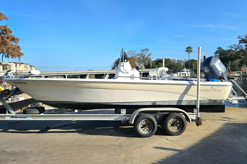Slide: The Image of 2007 NauticStar 2110 Nautic Bay boat on trailer, parked near waterfront. - 17