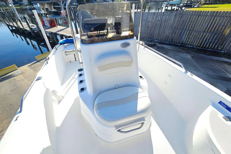 Slide: The Image of 2007 NauticStar 2110 Nautic Bay boat interior with seating and console, docked by water. - 8