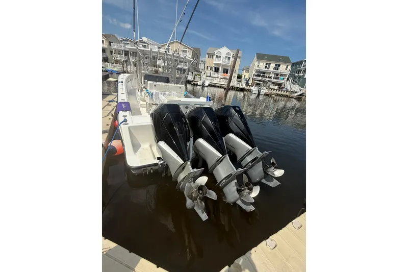 Slide: The Image of 2006 SeaVee 340B boat with triple outboard engines docked in a marina. - 10