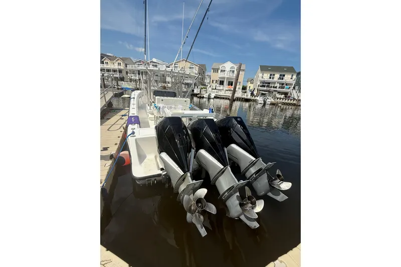 Slide: The Image of 2006 SeaVee 340B boat with triple outboard engines docked in a marina. - 11