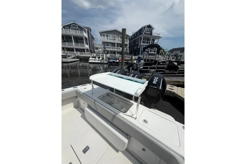 Slide: The Image of 2006 SeaVee 340B boat docked, featuring triple outboard engines, with waterfront homes in the background. - 12