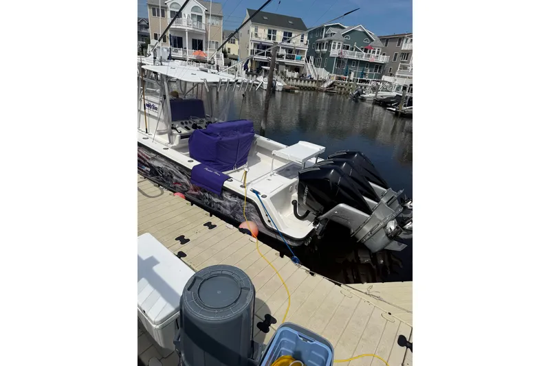 Slide: The Image of 2006 SeaVee 340B boat docked, featuring dual outboard engines and covered seating. - 16