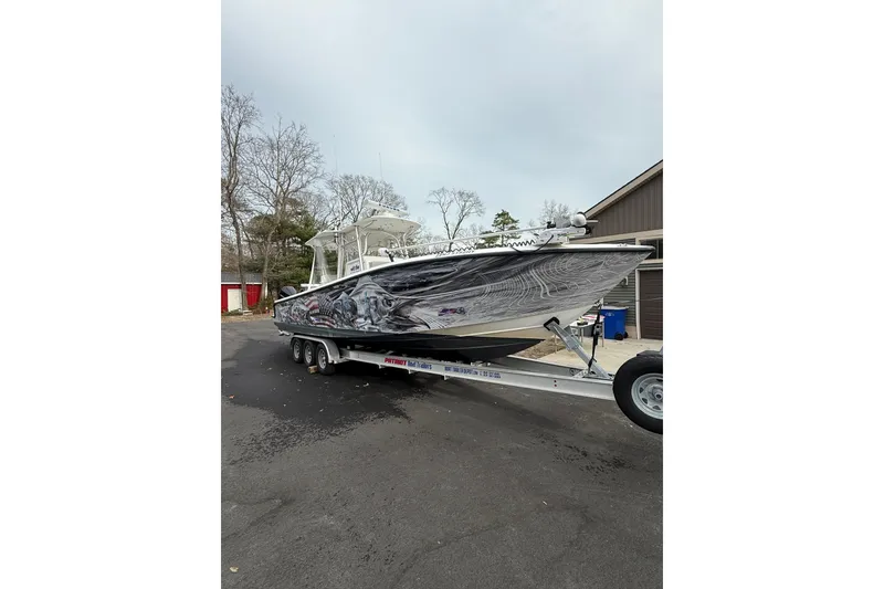 Slide: The Image of 2006 SeaVee 340B boat on trailer with custom graphics, parked outdoors. - 21