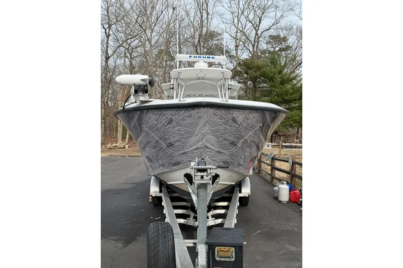 Slide: The Image of 2006 SeaVee 340B boat on trailer, parked outdoors with trees in background. - 22