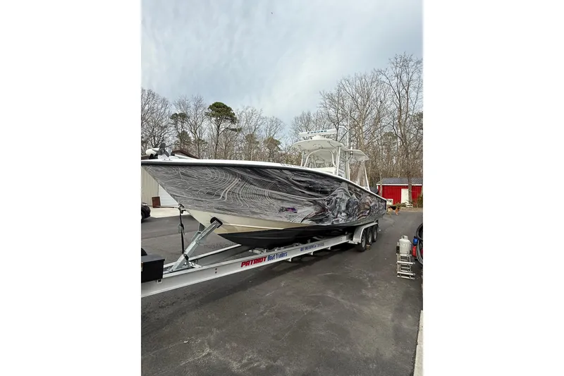 Slide: The Image of 2006 SeaVee 340B boat on trailer, parked outdoors with trees in background. - 23