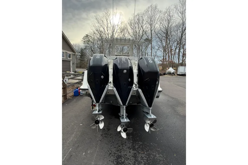 Slide: The Image of 2006 SeaVee 340B boat with triple outboard engines, parked on a driveway. - 24