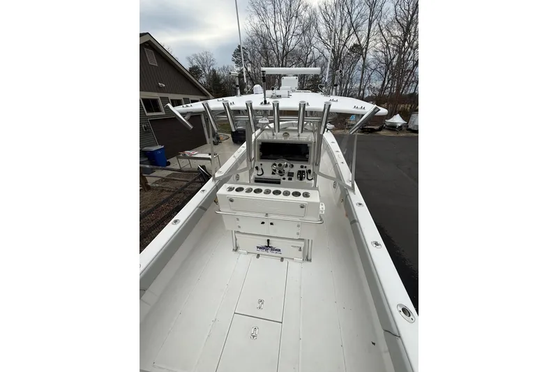 Slide: The Image of 2006 SeaVee 340B boat interior with console and rod holders, docked near trees. - 30