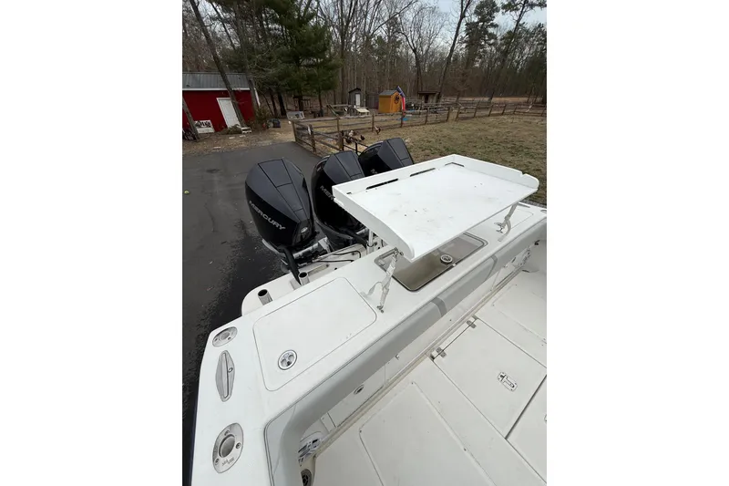 Slide: The Image of 2006 SeaVee 340B boat with triple Mercury outboard engines, parked outdoors. - 34
