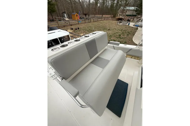 Slide: The Image of 2006 SeaVee 340B boat with gray cushioned seating and rod holders, parked outdoors. - 44