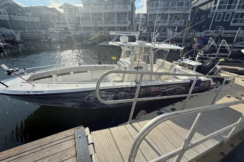 Slide: The Image of 2006 SeaVee 340B boat docked at marina with fishing rods and American flag design. - 5
