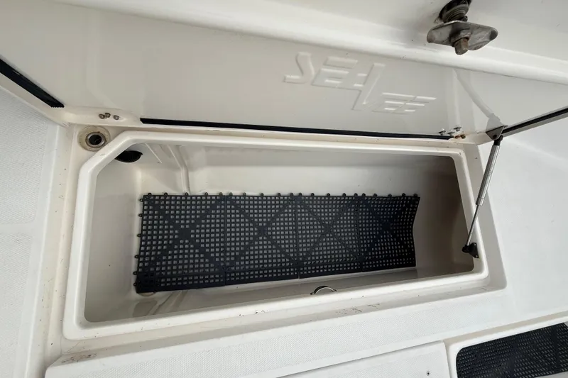 Slide: The Image of Open storage compartment on a 2006 SeaVee 340B boat, featuring a black mat inside. - 63