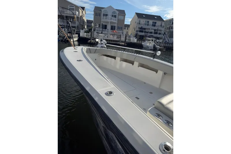 Slide: The Image of 2006 SeaVee 340B boat docked near waterfront homes, showcasing spacious deck. - 7