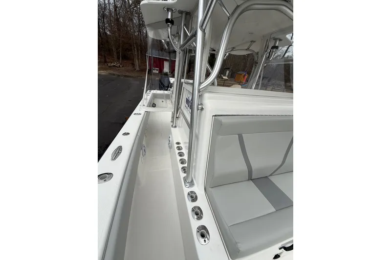 Slide: The Image of 2006 SeaVee 340B boat interior with seating and rod holders, docked outdoors. - 73