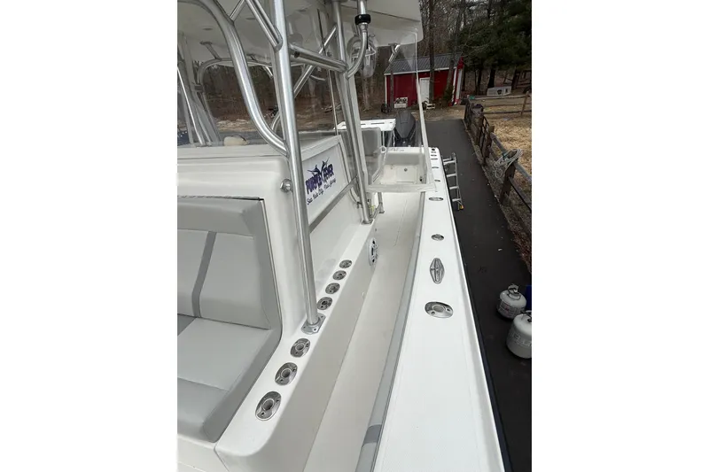 Slide: The Image of 2006 SeaVee 340B boat deck with seating and rod holders, parked outdoors. - 75