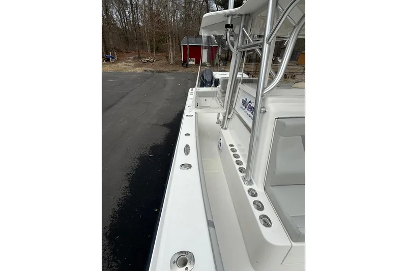 Slide: The Image of 2006 SeaVee 340B boat with sleek white deck and sturdy railings, parked outdoors. - 76