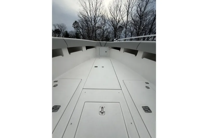 Slide: The Image of 2006 SeaVee 340B boat deck with storage compartments, surrounded by bare trees. - 79